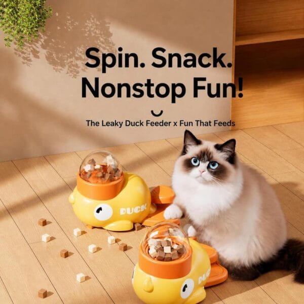cat-dog-toys-31-5 leaky duck treat dispenser pet using scene fluffy ragdoll cat touching duck toy with scattered pet food pellets on wooden floor