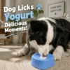 pet-lick-bowl-35-6 dog enrichment lick bowl real usage scene shot black and white border collie licking yogurt from blue spill proof treat bowl placed on woven round mat inside bright living room home space